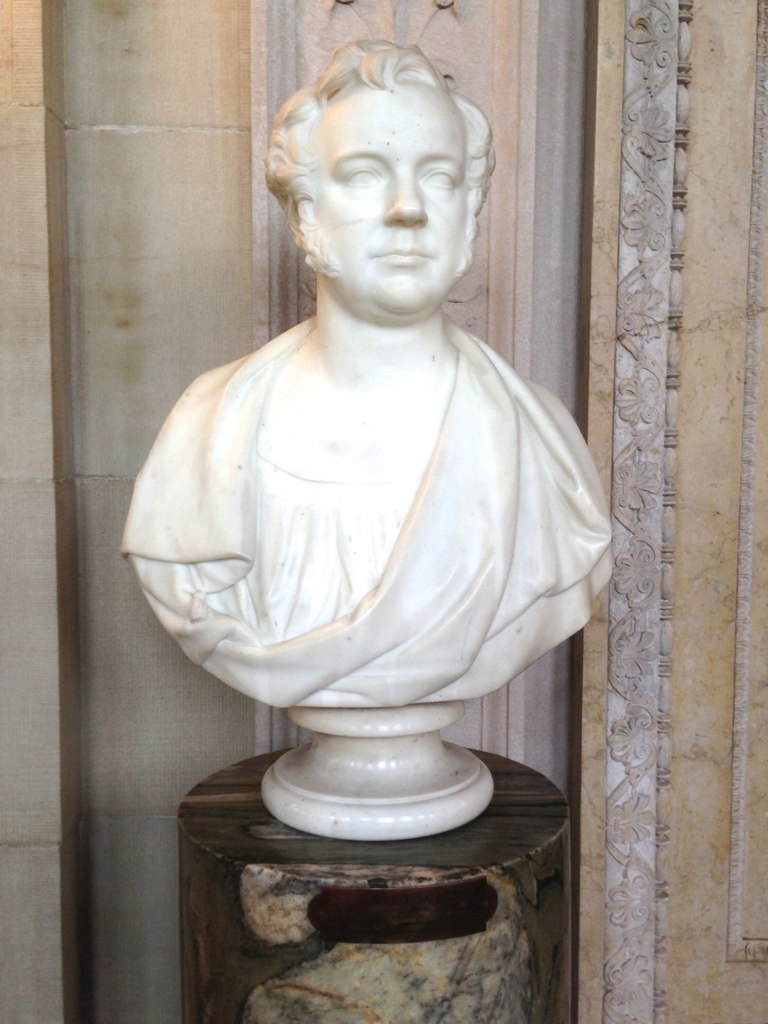 a statue of a man with a collar is shown next to a doorway