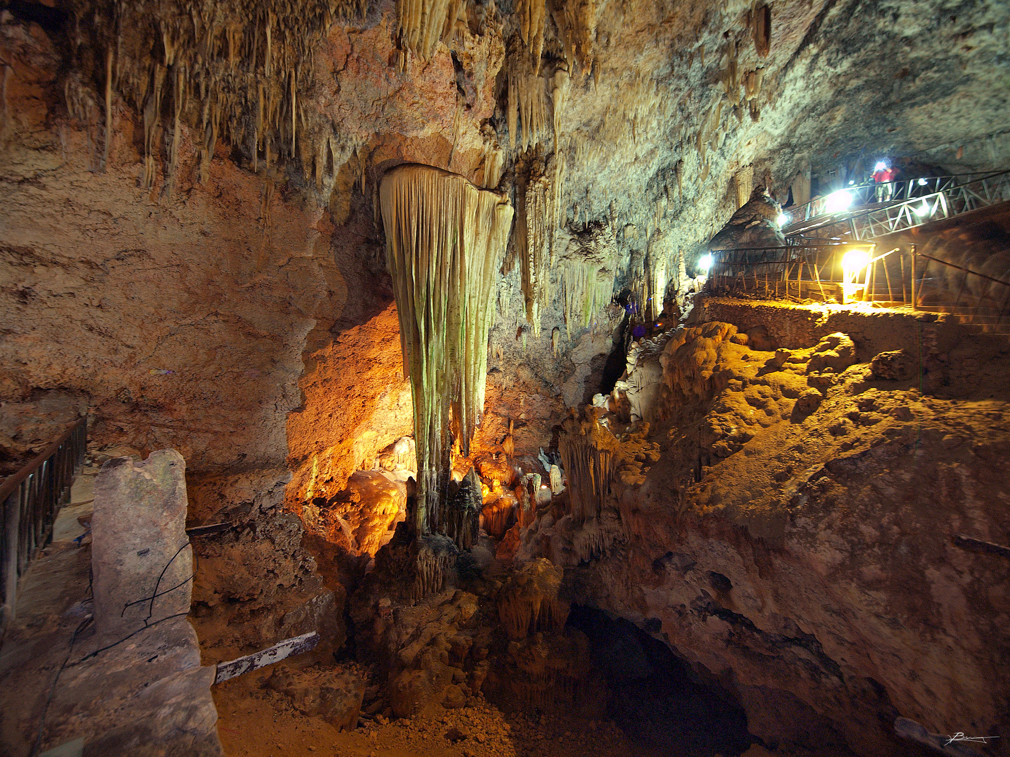 people stand on an open air cavern in a cave