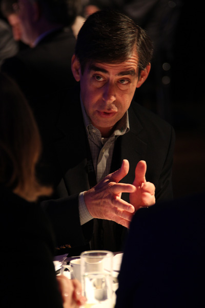a man sitting at a table with a finger up