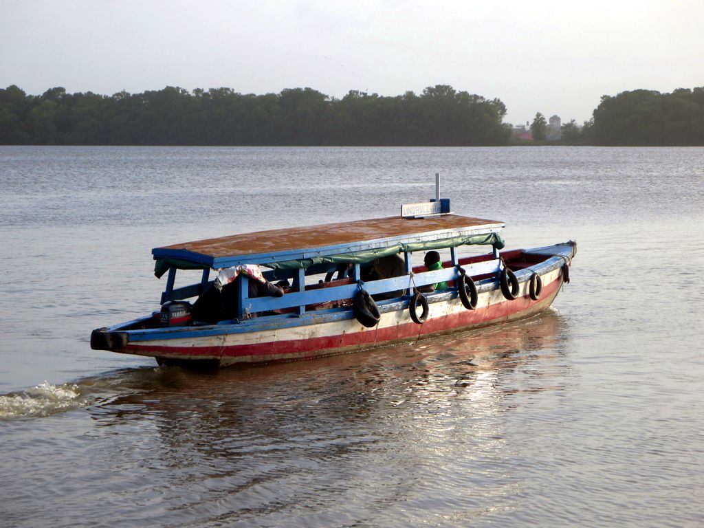 a small boat with two passengers travelling down the water