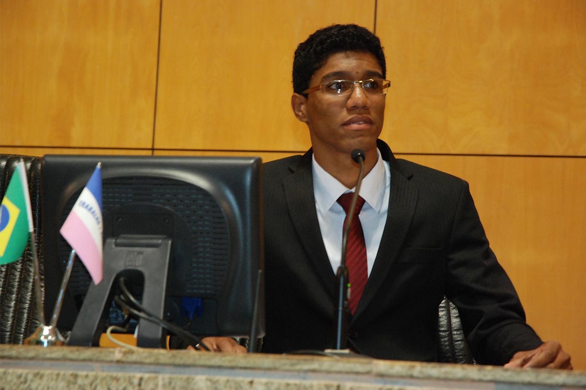 a person wearing a suit in front of a desk