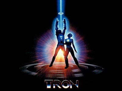 two people stand in front of a laser light, which is lit up from behind and text that reads,'tron '