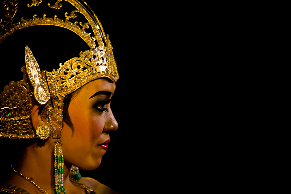 a woman is wearing a head dress made of gold