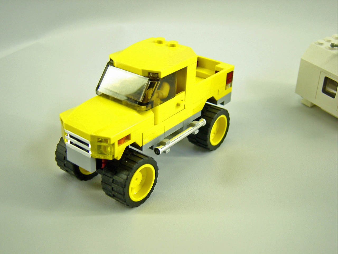 yellow truck and white car on a table