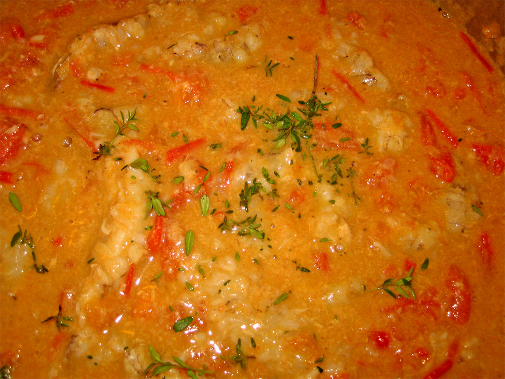 a casserole dish with meat and vegetables being cooked