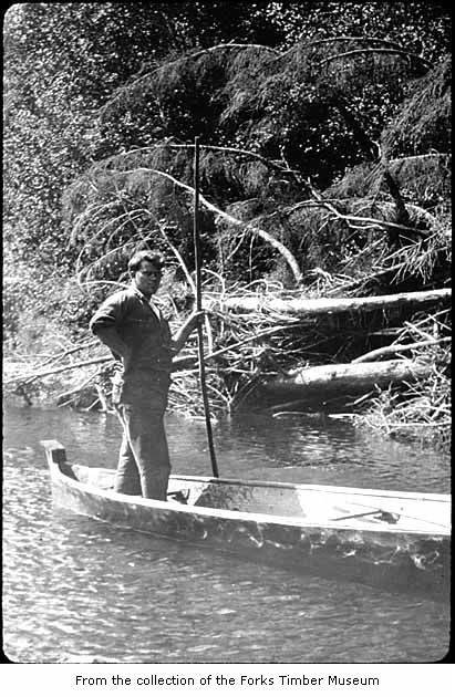 a man standing in a canoe on a river