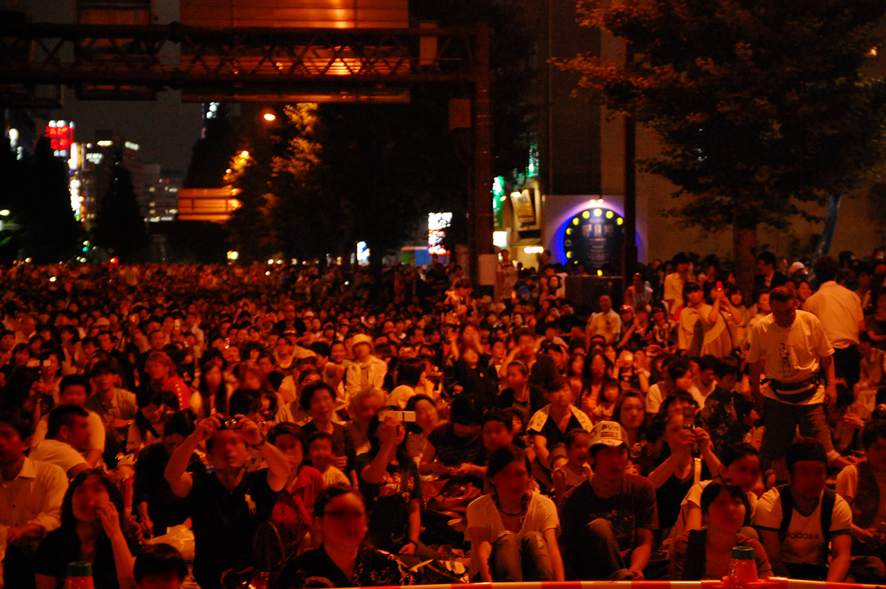 many people gathered together for an event at night