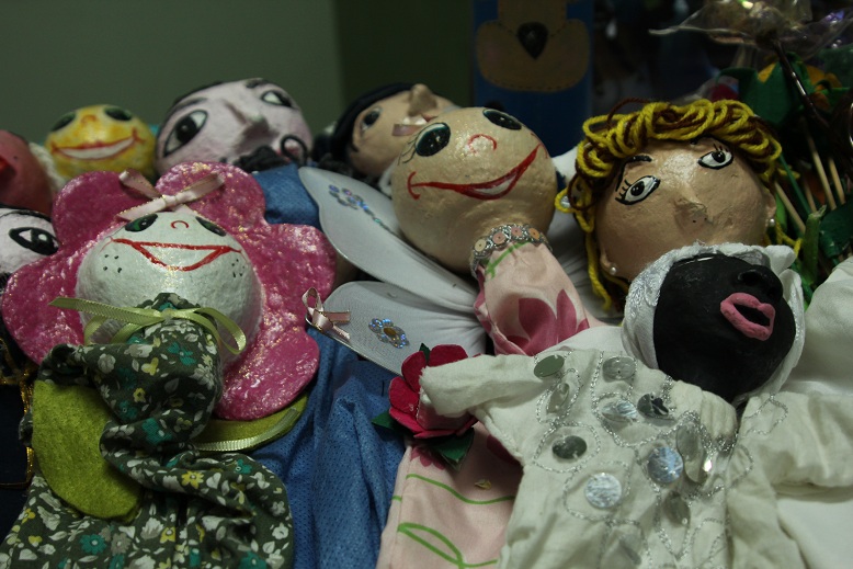a pile of old dolls sit in a corner