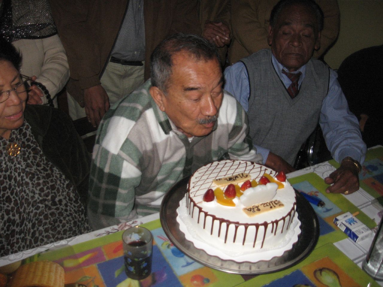 an elderly gentleman  a cake on a table