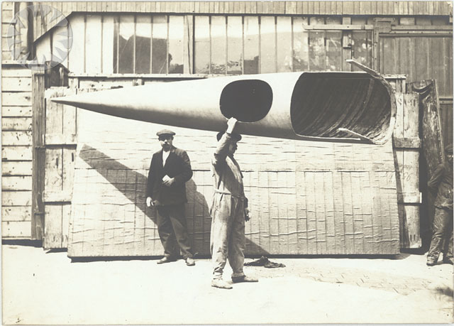 a black and white po of a man standing next to a giant rocket