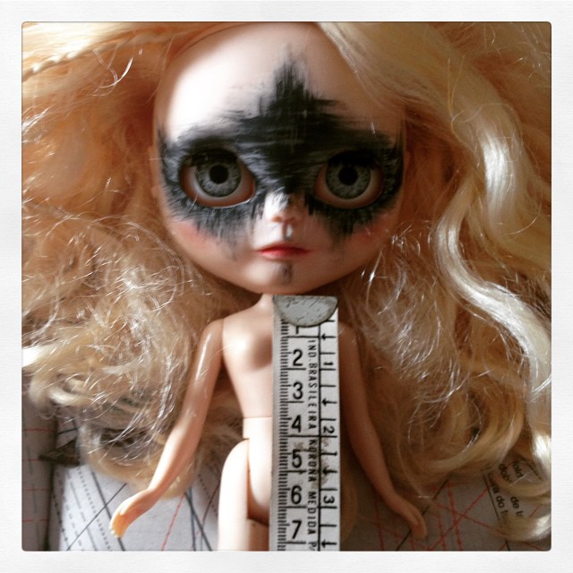a doll has her head on a ruler