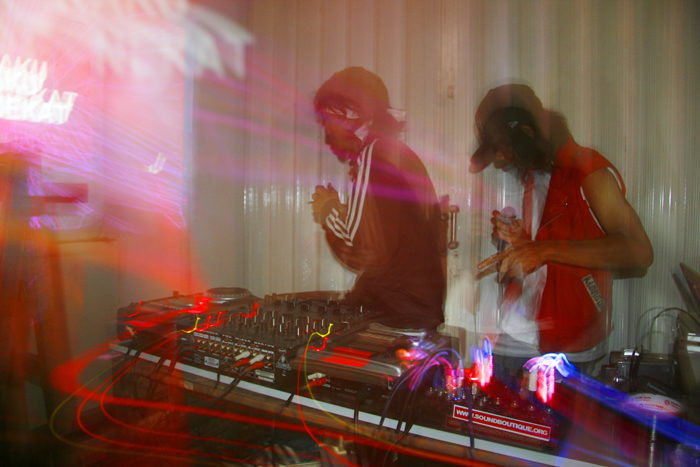 a couple of men standing next to each other with dj equipment