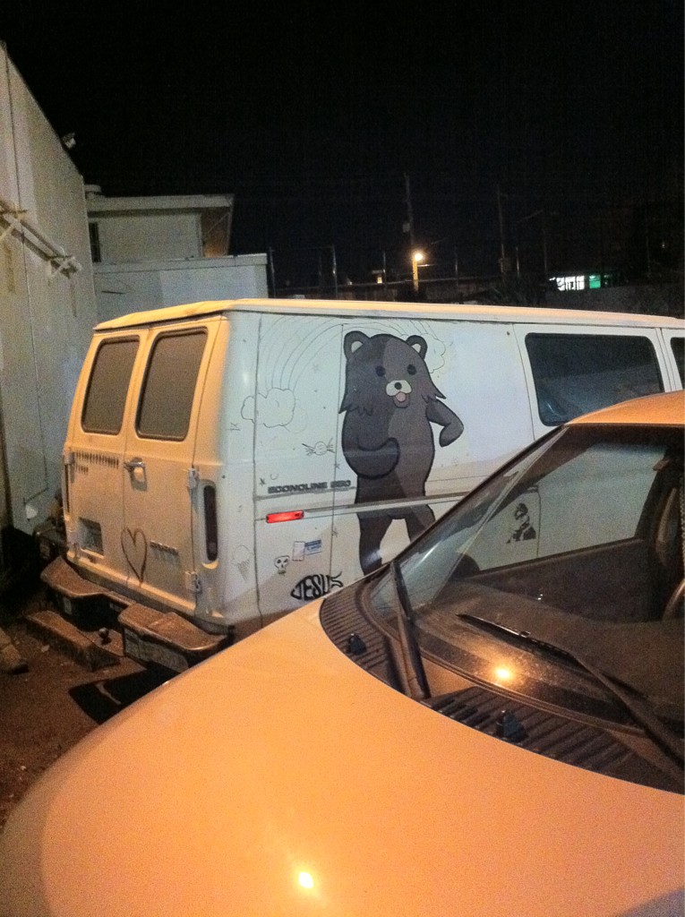 white van with a drawing on it on the side of a road at night