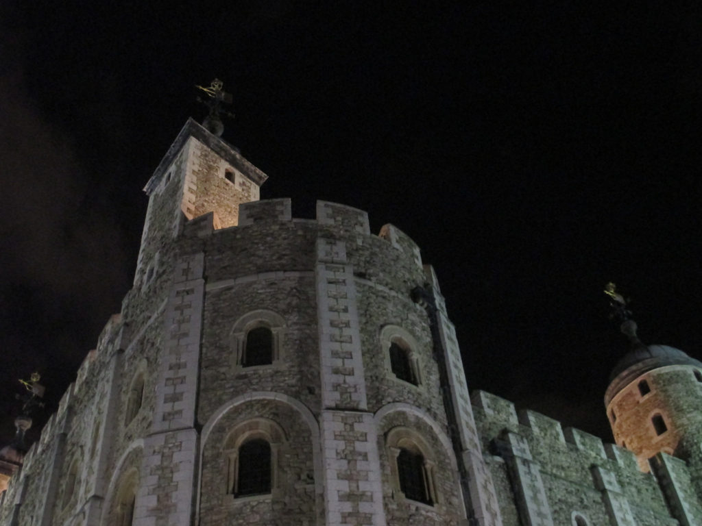 an old castle has its clock showing at night