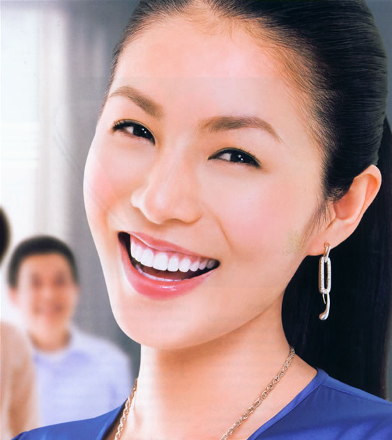an attractive lady with large smile and earrings
