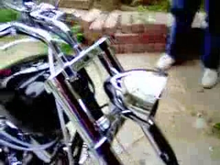 the side view of a parked motorcycle on a brick driveway