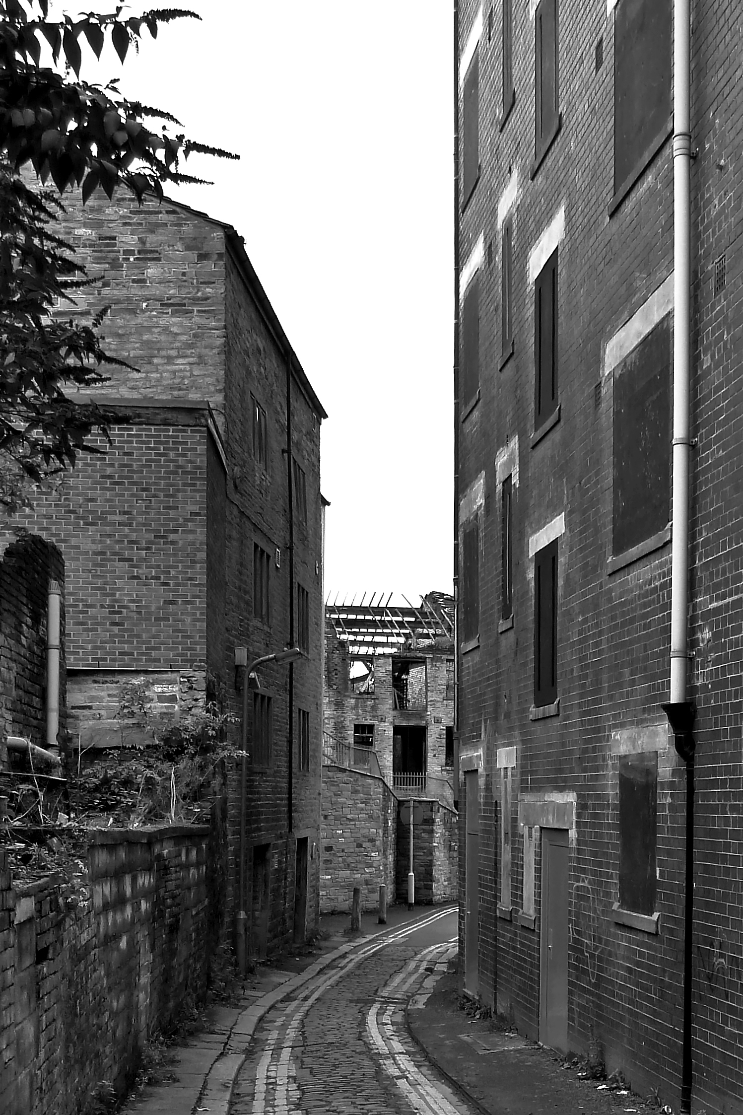 a narrow alley with brick buildings on both sides