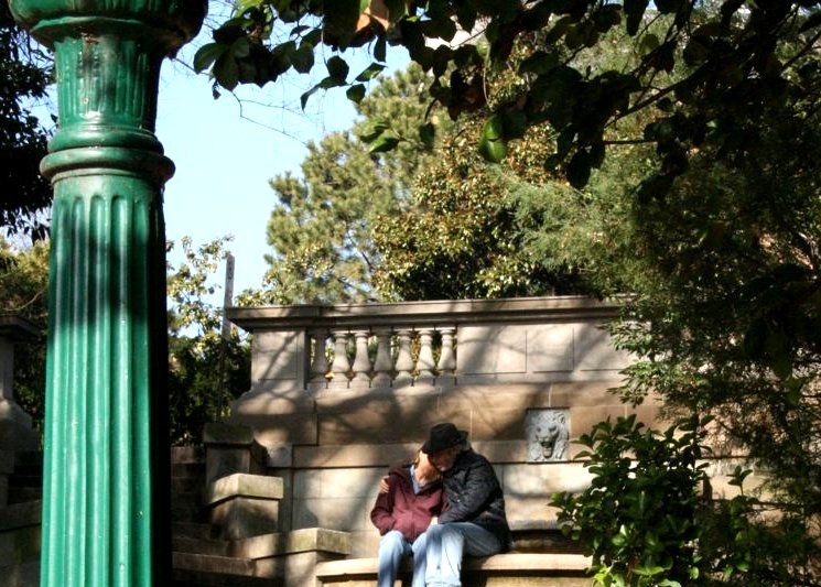 a man sitting on a green street post