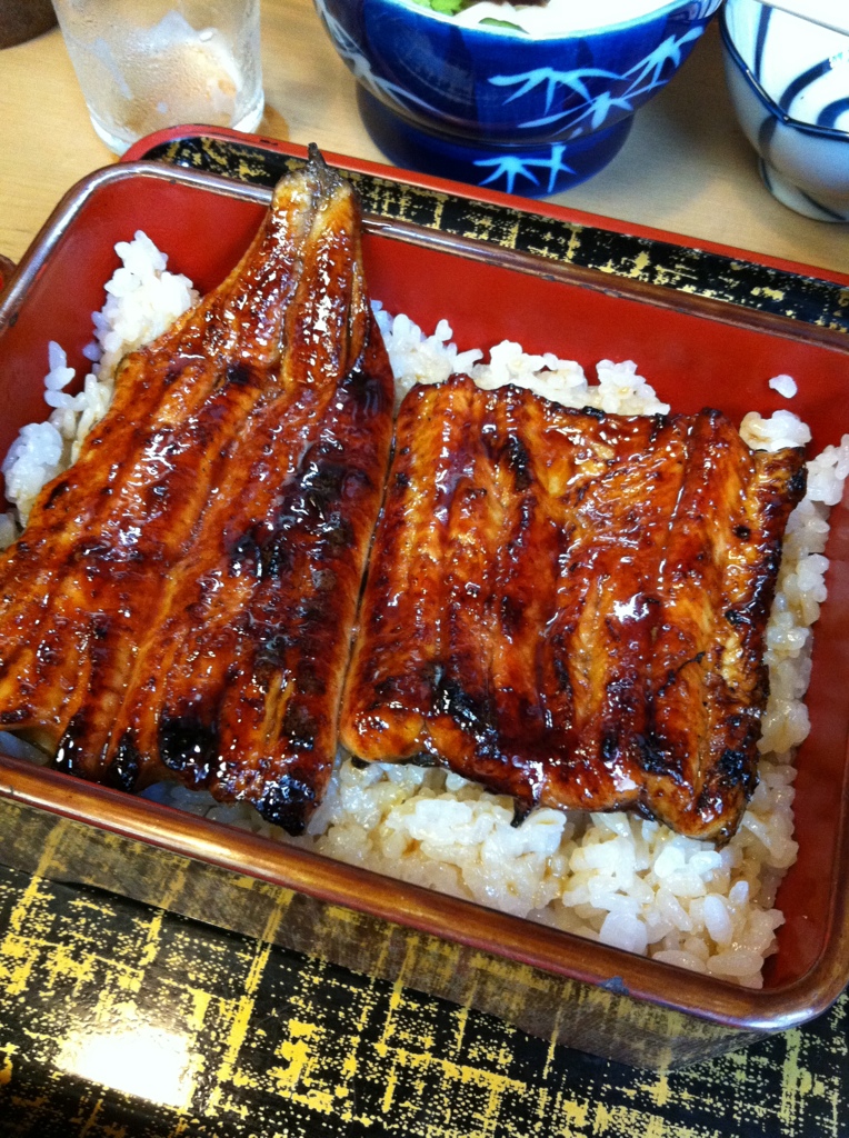 a red tray topped with rice covered in bacon