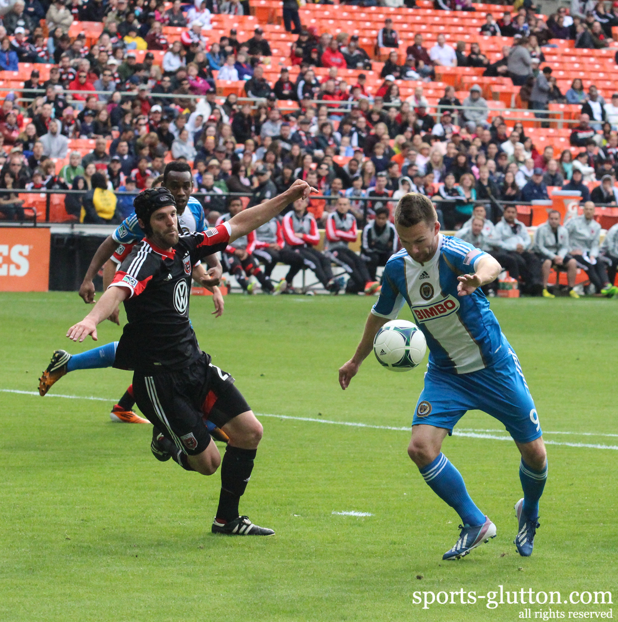 a group of men playing soccer on a soccer field