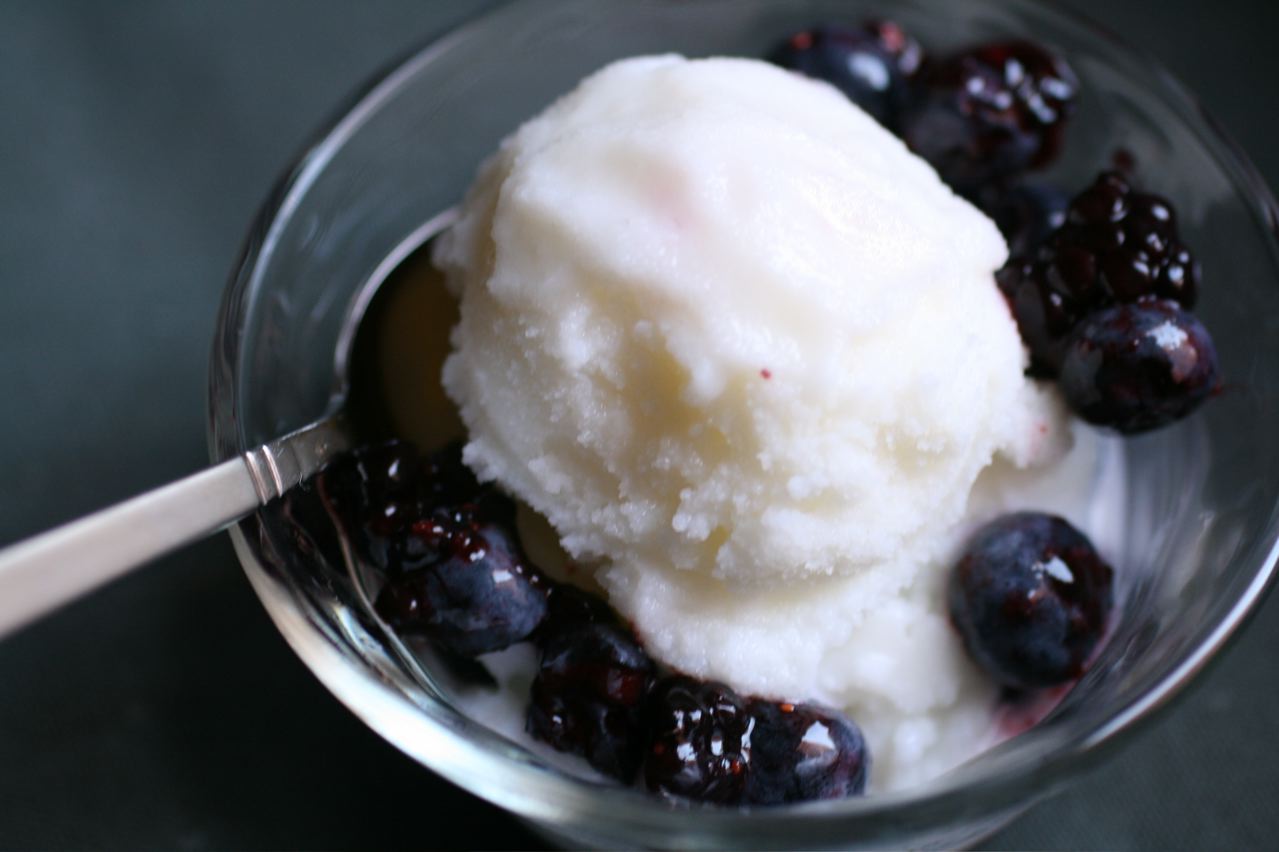 a dessert in a glass bowl with blueberries