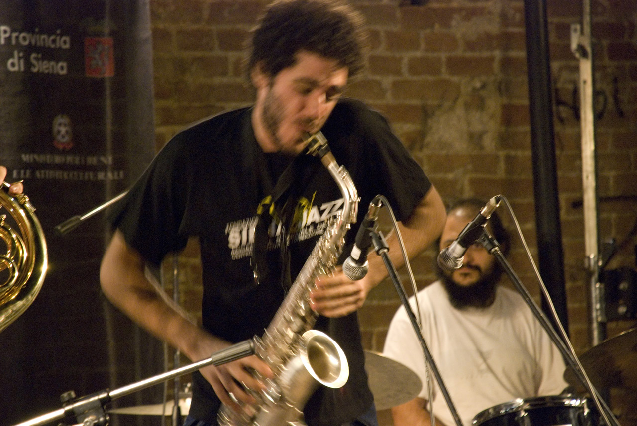 man playing musical instrument in front of two musicians