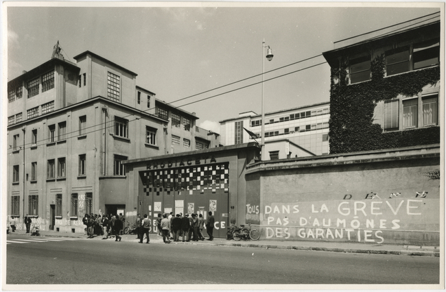 black and white pograph of people at an entrance to a building