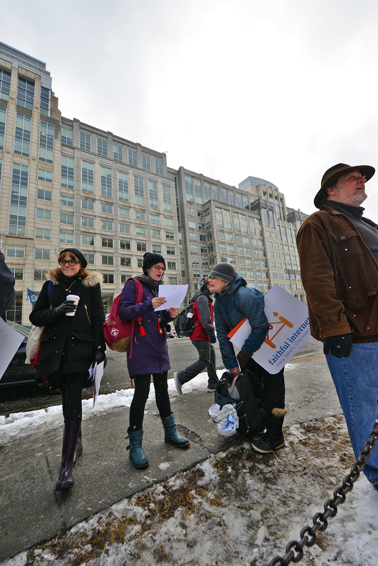 people holding signs as a man walks down the street