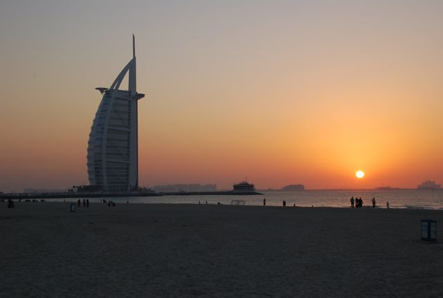 a tall building standing on top of a sandy beach