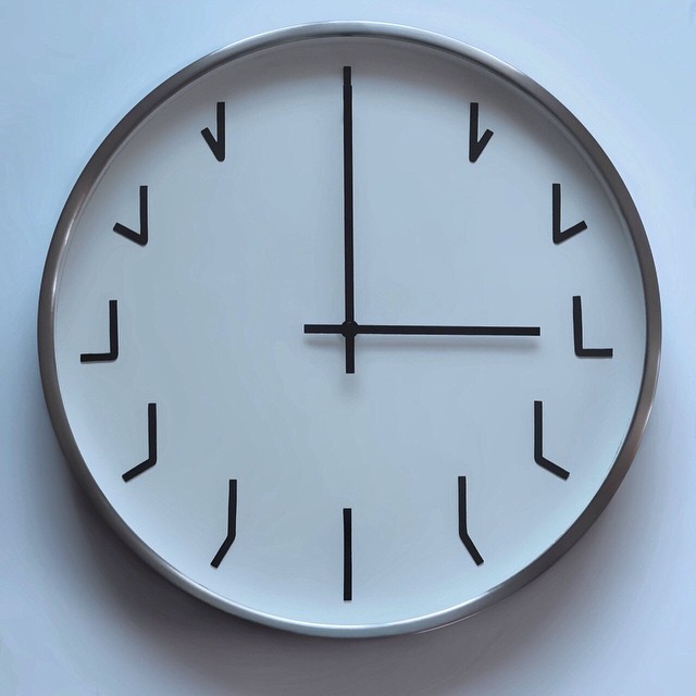a wall clock with arrows and numbers on the face of it