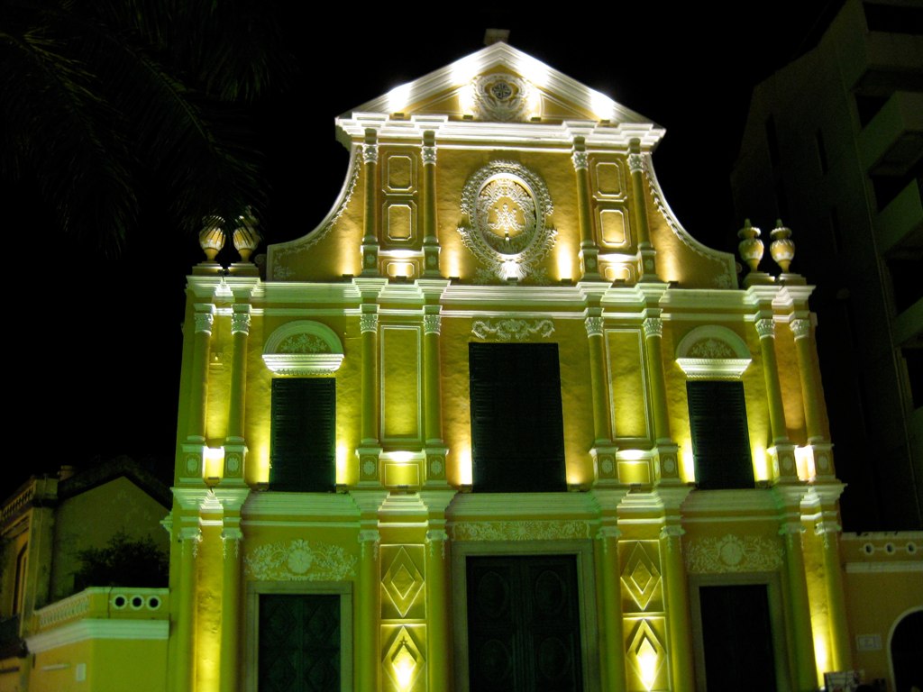 lighted building with clock and statue on top of it