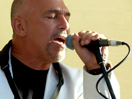 a man standing in front of a microphone and singing