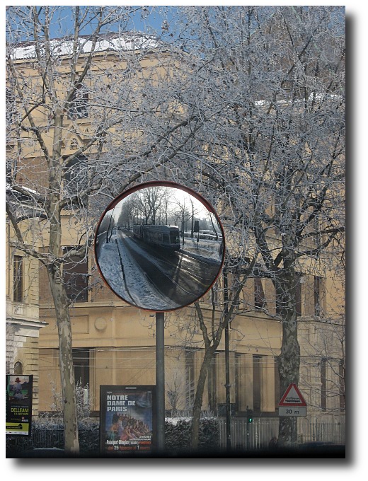 an old building with a mirror showing a landscape in the reflection