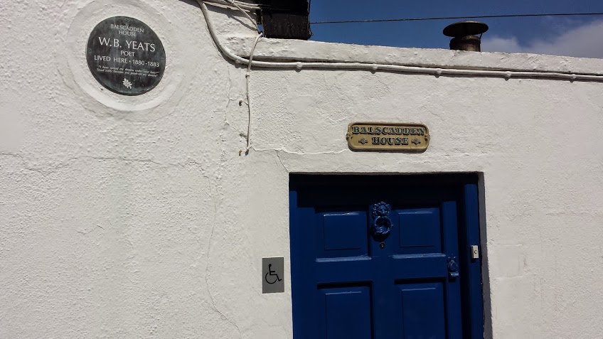the entrance to the museum with a blue door and plaque on the wall