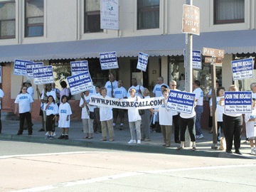 a group of people holding signs standing in front of a building