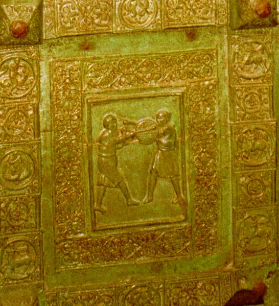 a green metal work with gold paint is shown
