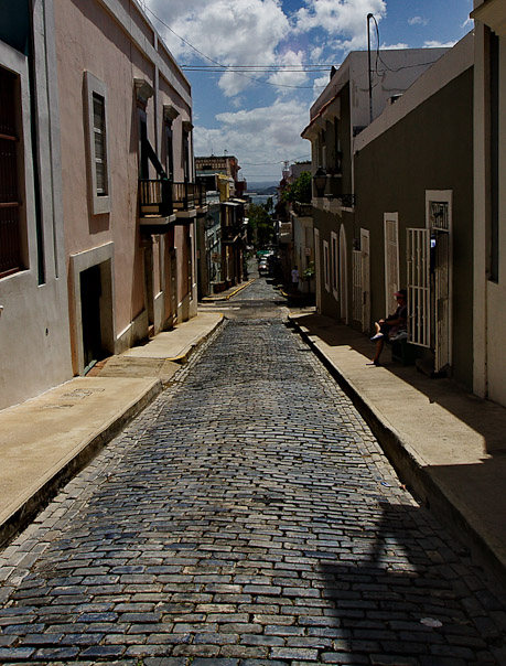 a stone street is lined with brick buildings