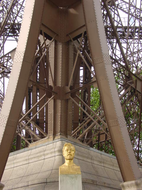 a close up of a golden head on a white pedestal