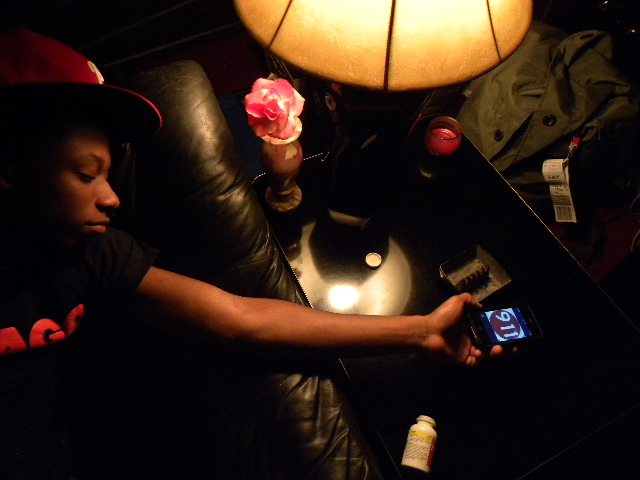 a young man using his cell phone to operate a lamp