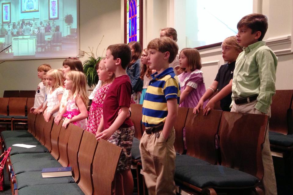 a large group of children in front of an audience