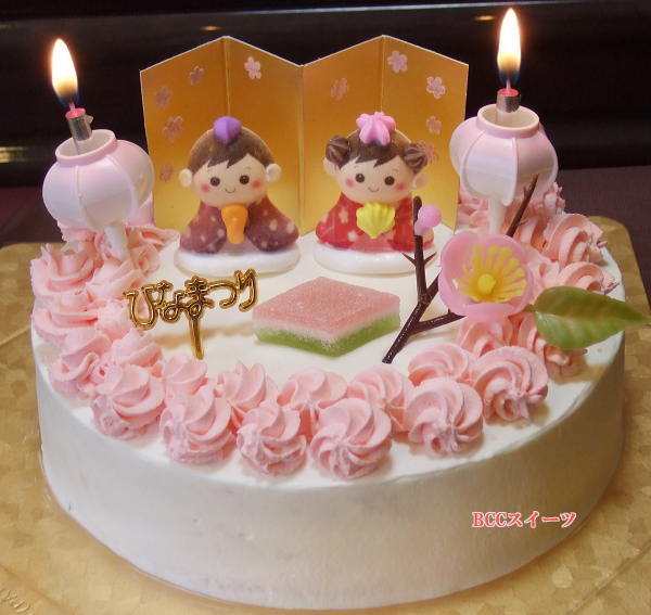 cake with two small candle sticks and pink roses