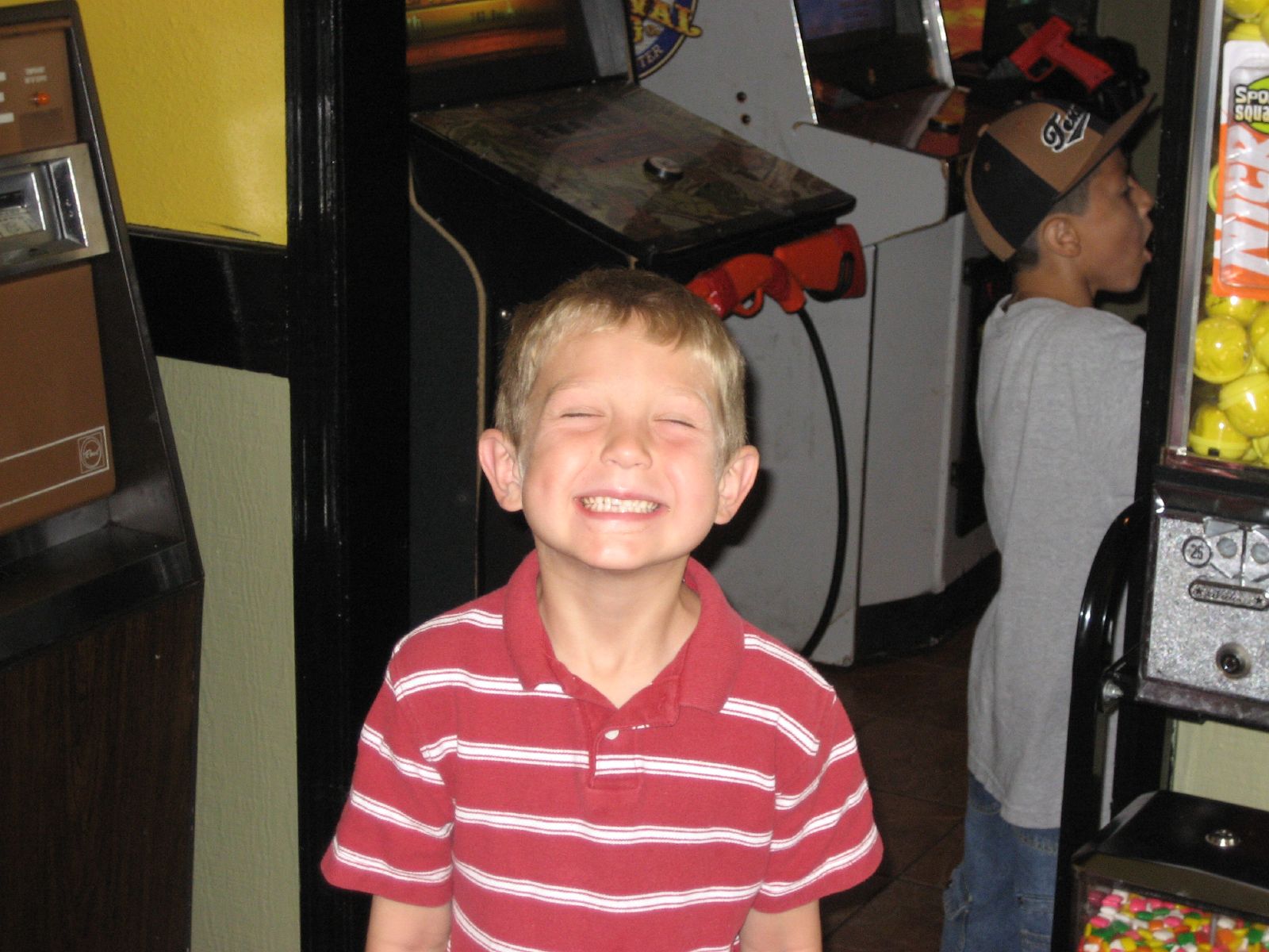 a boy in a red and white shirt is by a machine