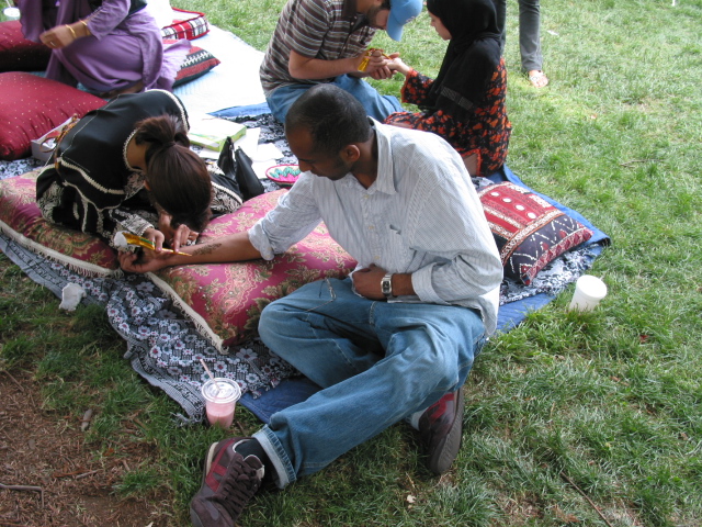 there is a man sitting on a blanket in the park