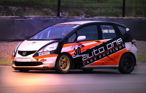 a small car is painted with orange and black stripes