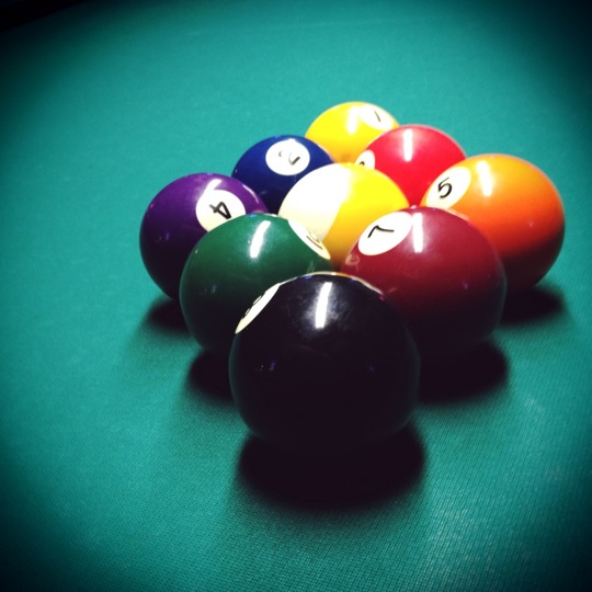 billiard balls and their cues lined up in a game