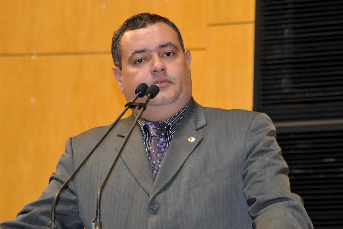 a man wearing a gray suit holding a microphone