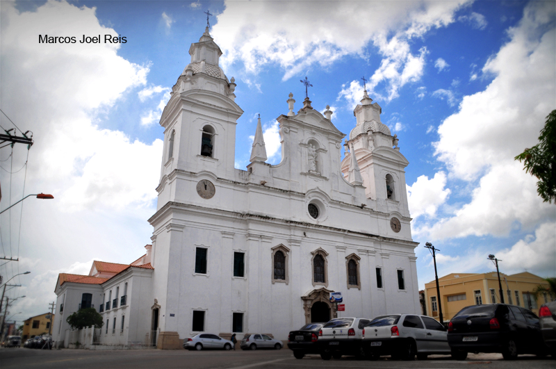 a church with towers on the top, next to cars