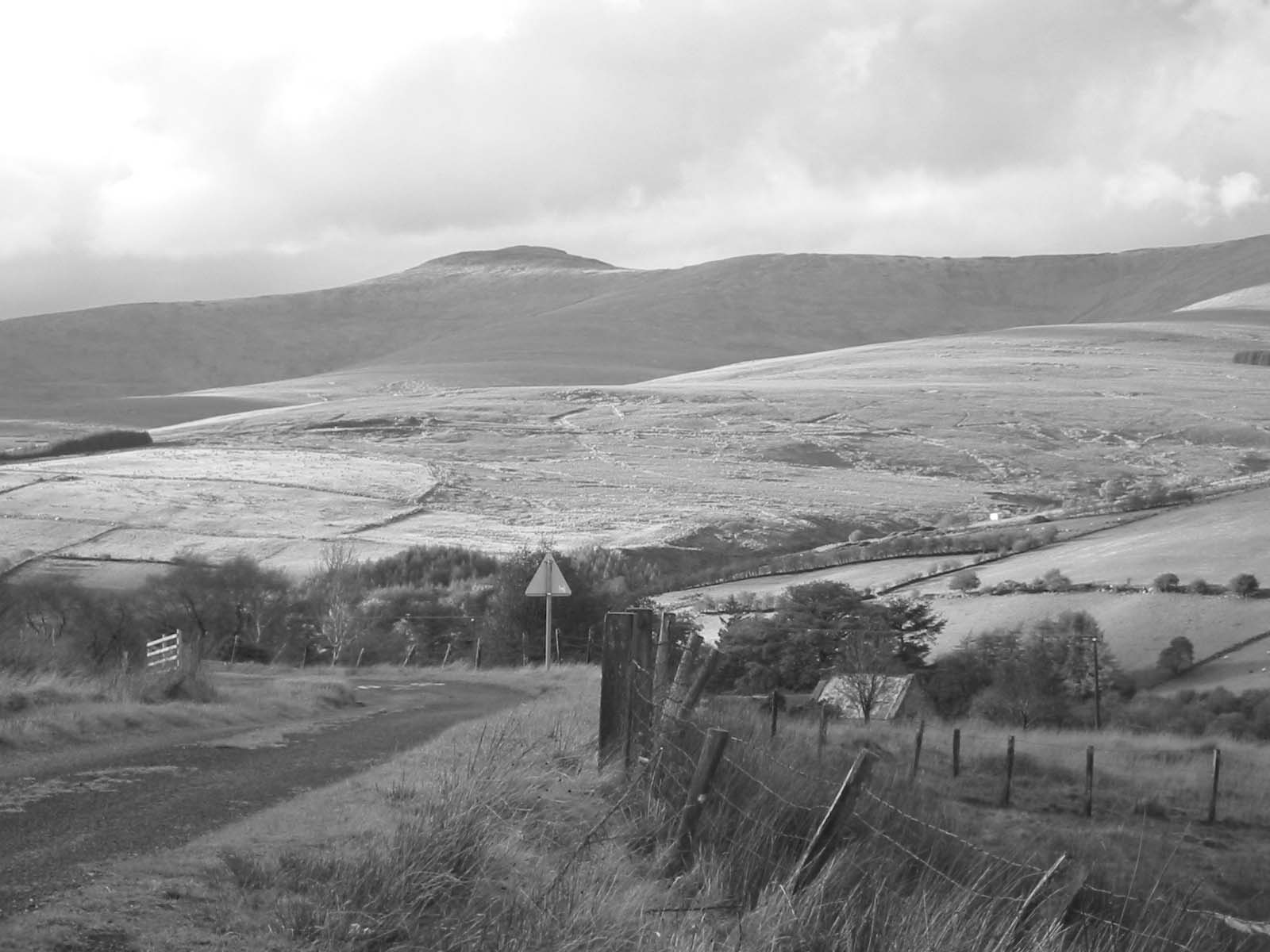 black and white image of mountains with a trail to the top