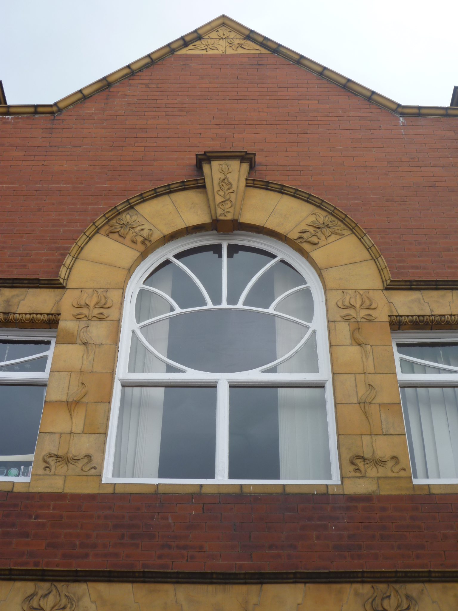 two windows on a brick building that have decorative designs