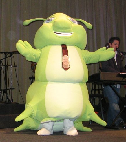 a green inflatable costume on display in front of a microphone